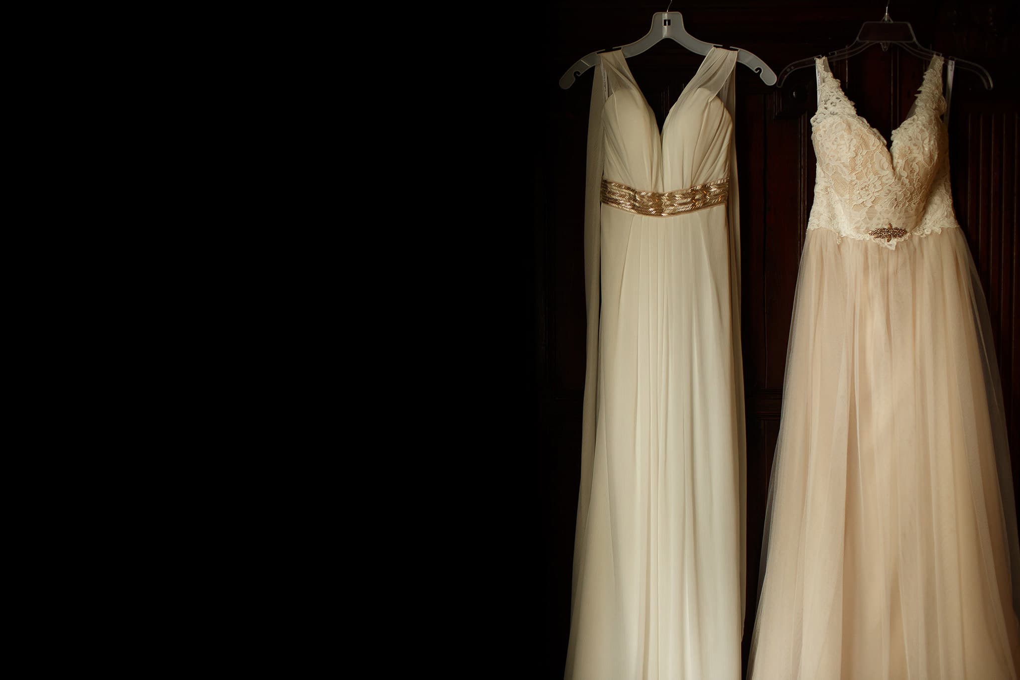 two long brides dresses hung on the wardrobe together - great hall at mains wedding photography