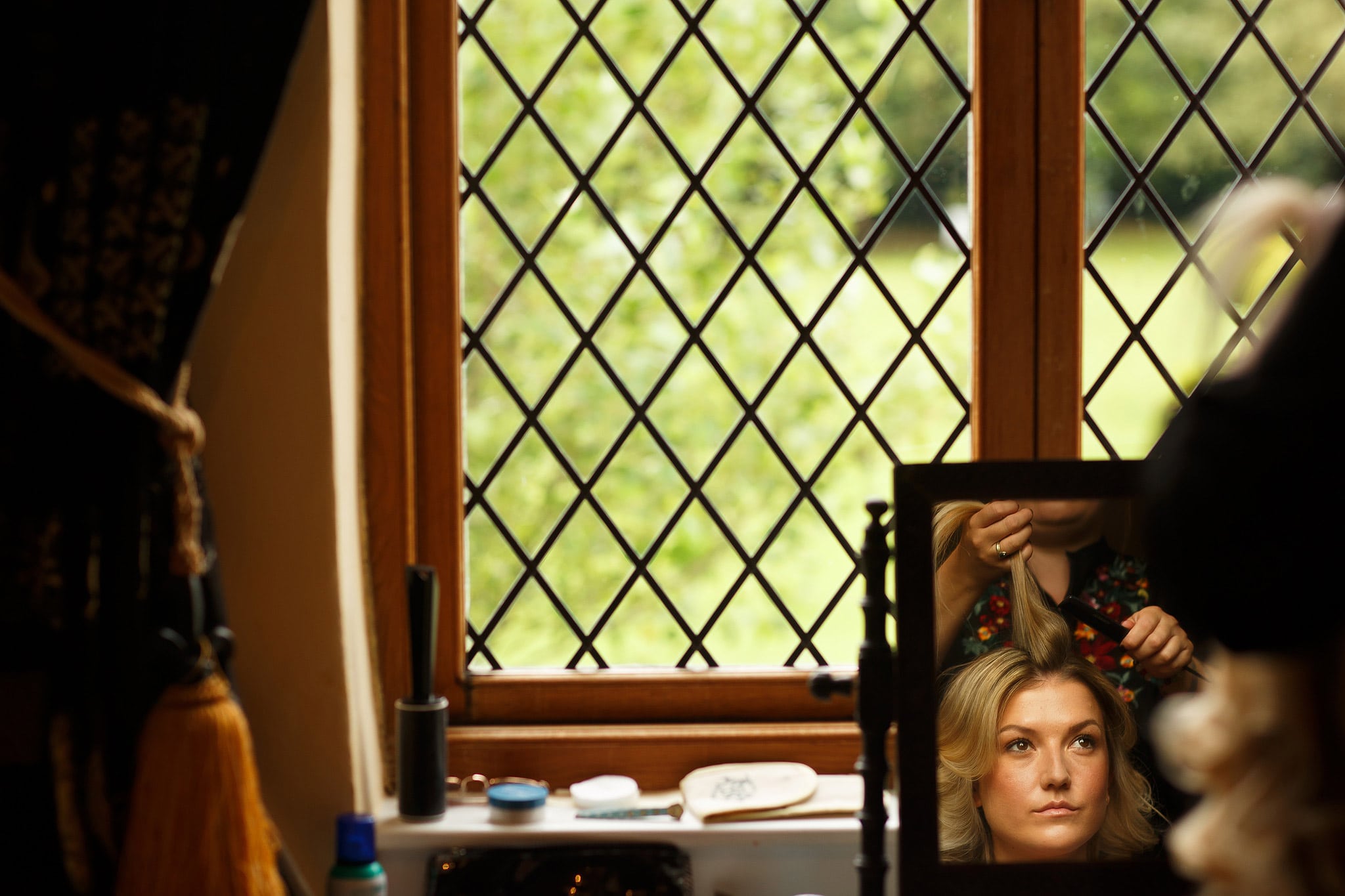 Bride having her hair curled by hairdresser - great hall at mains wedding photography