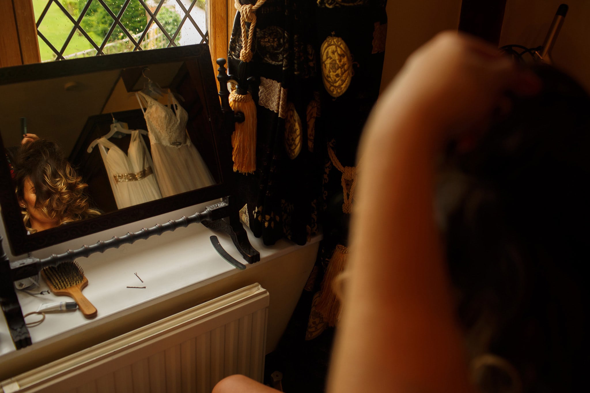 Bride having make up applied while dresses are seen in the reflection of the mirror - great hall at mains wedding photography