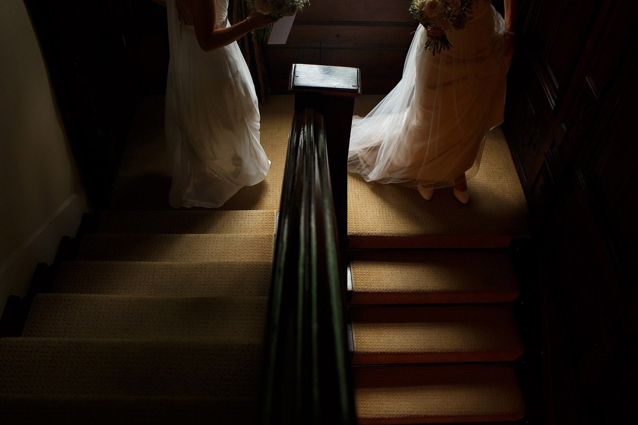Brides walking down the stairs together inside the house - great hall at mains wedding photography