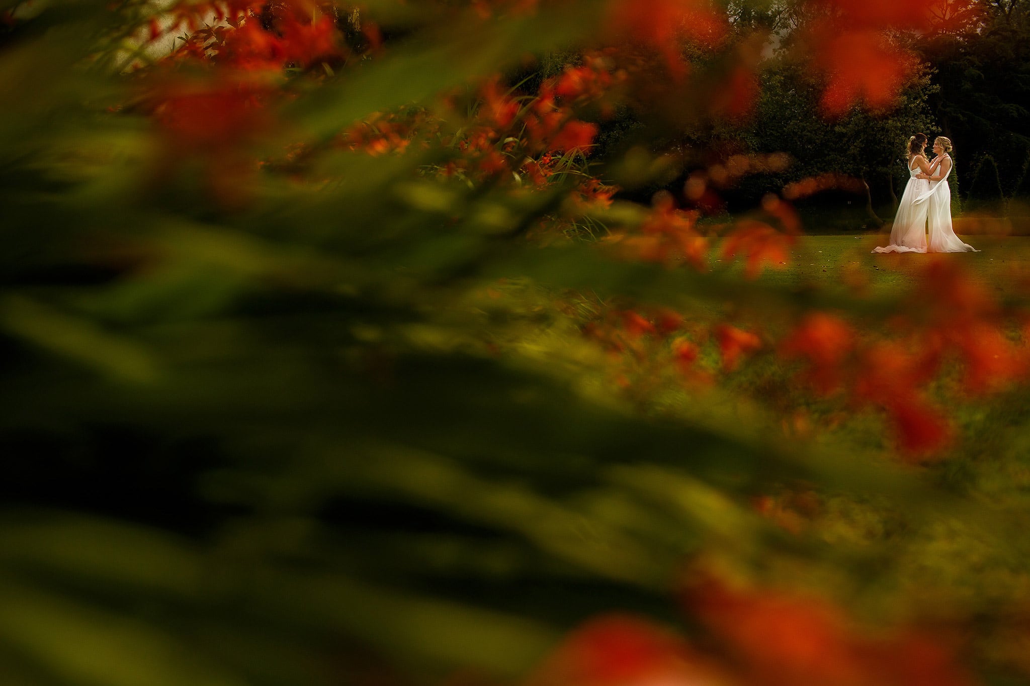 brides in the gardens at Great Hall at Mains framed by the flowers in the gardens 