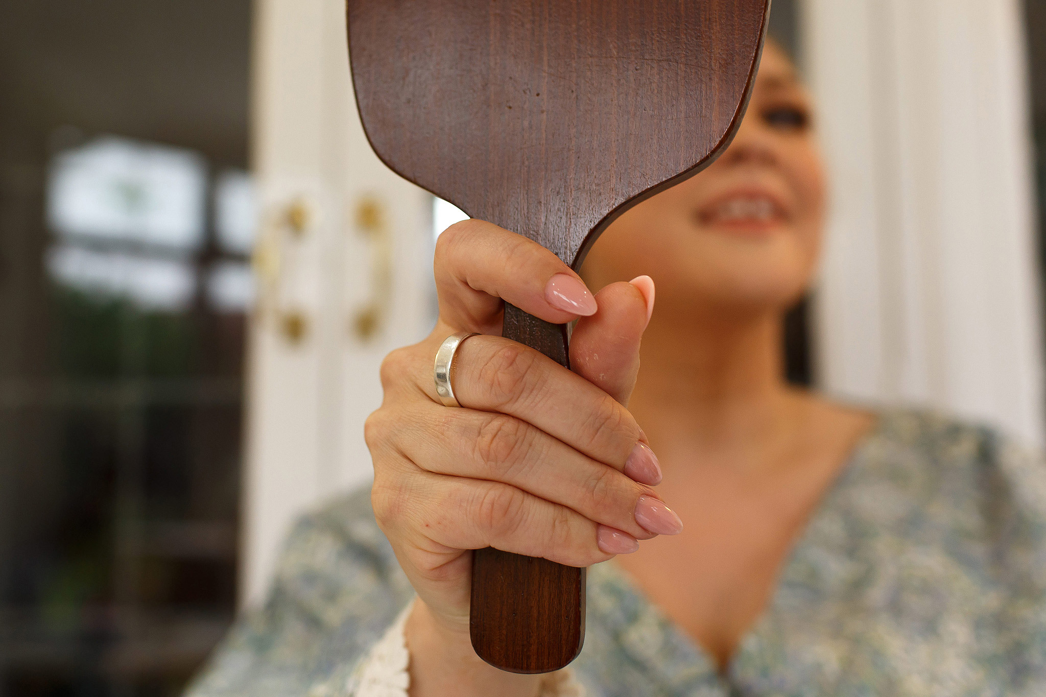Bride looking into hand held mirror