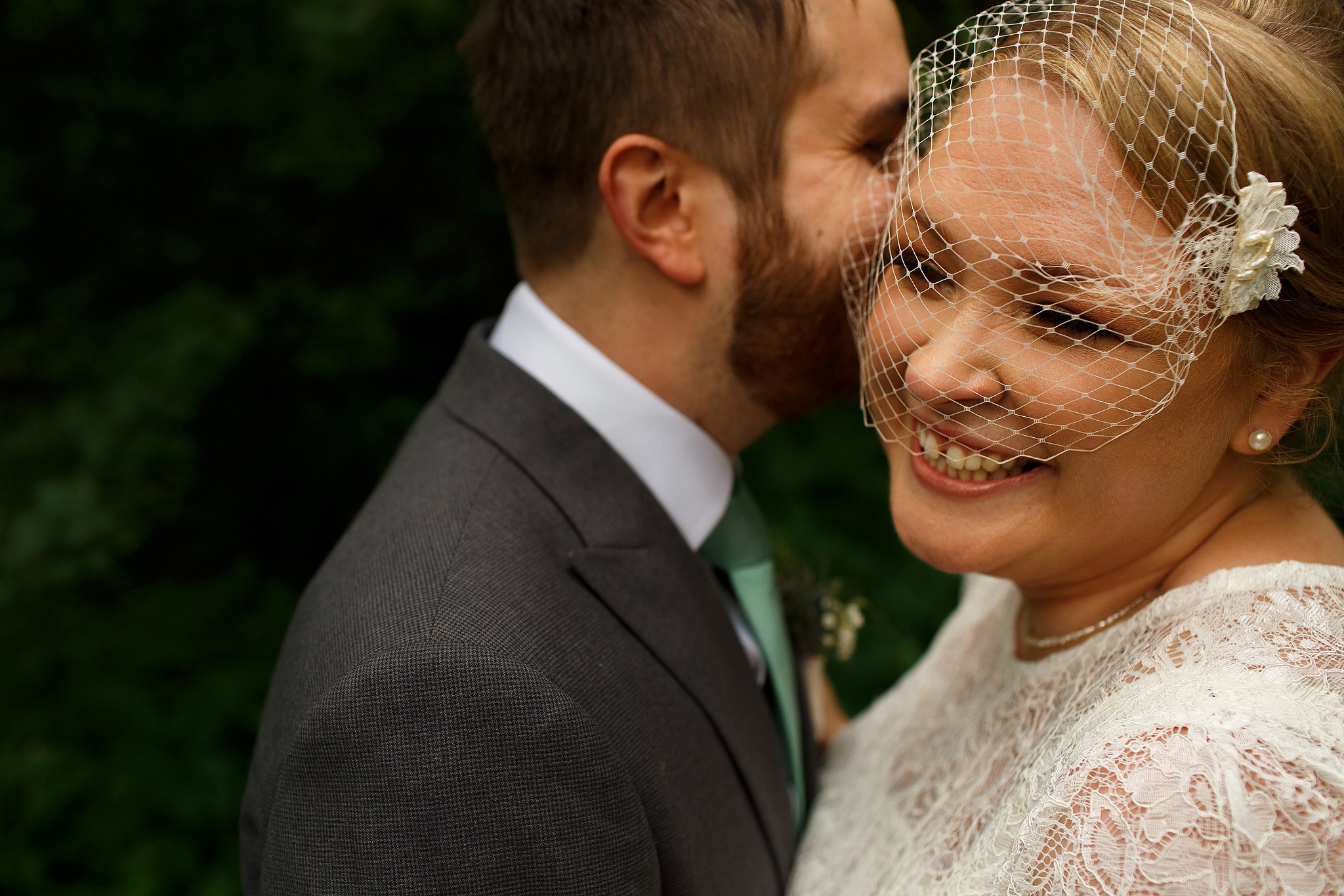 Close up portrait of bride wearing birdcage veil and groom during portraits in the countryside at the Oak Tree at Peover wedding