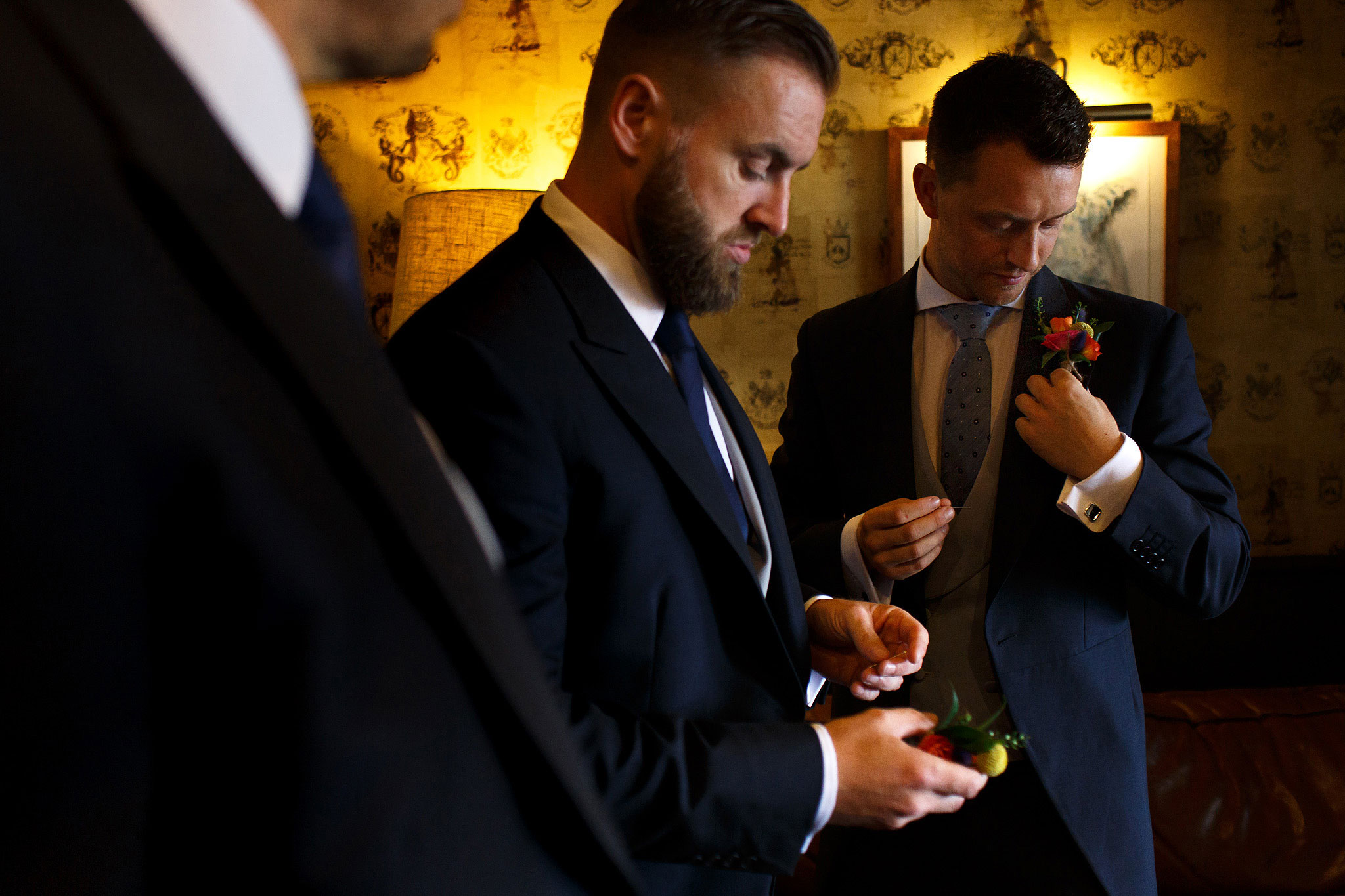 Groom and groomsmen fixing on their button hole flowers