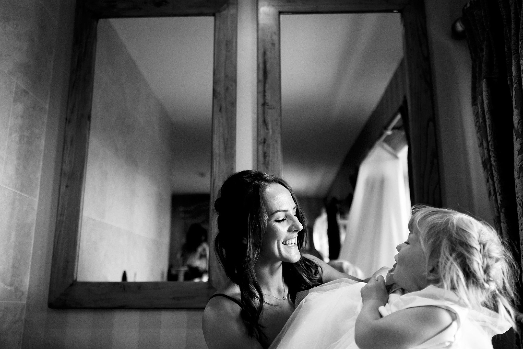 Bride and flower girl laughing looking towards each other