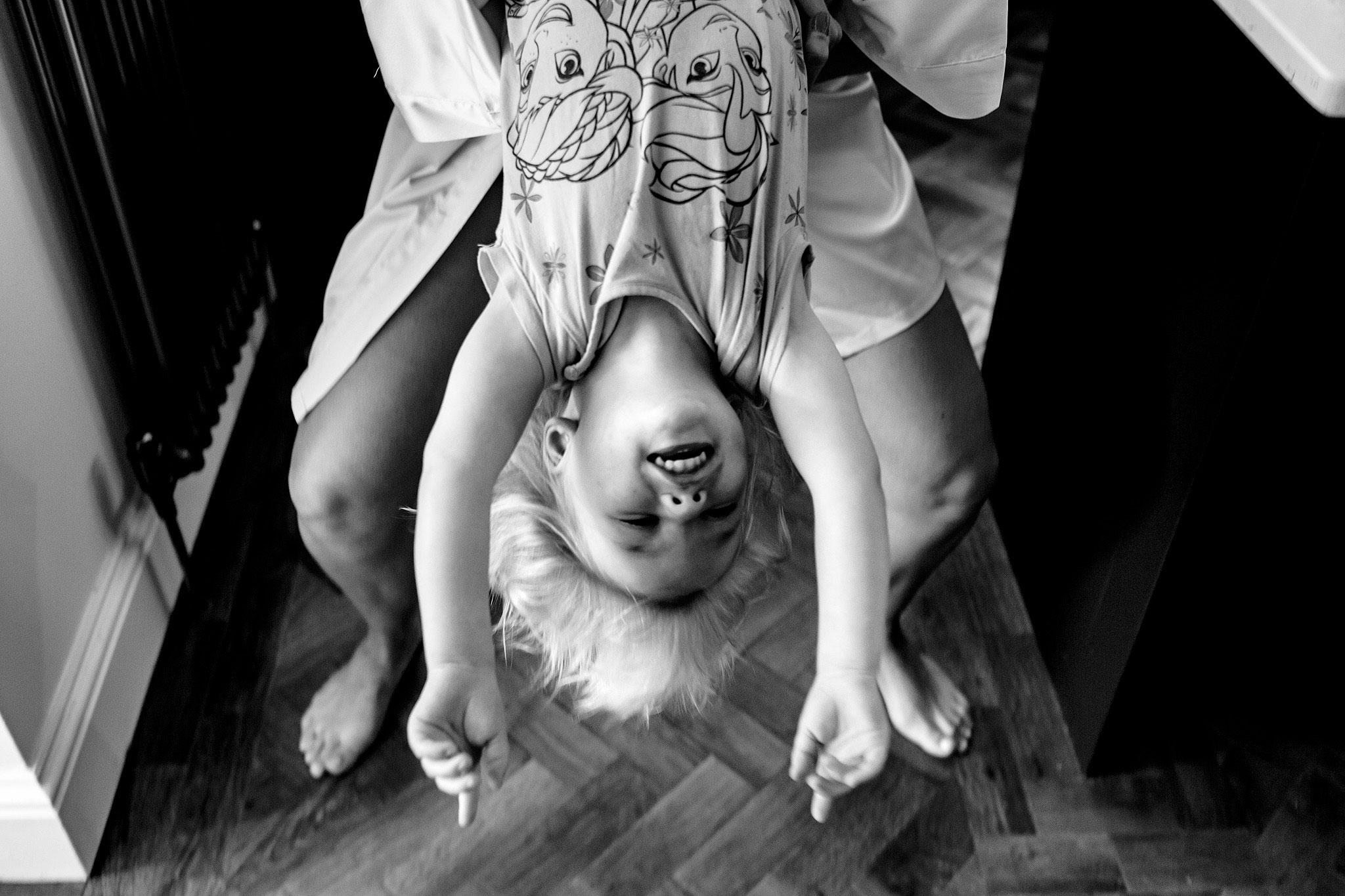 Black and white photograph of a small child handing upside down