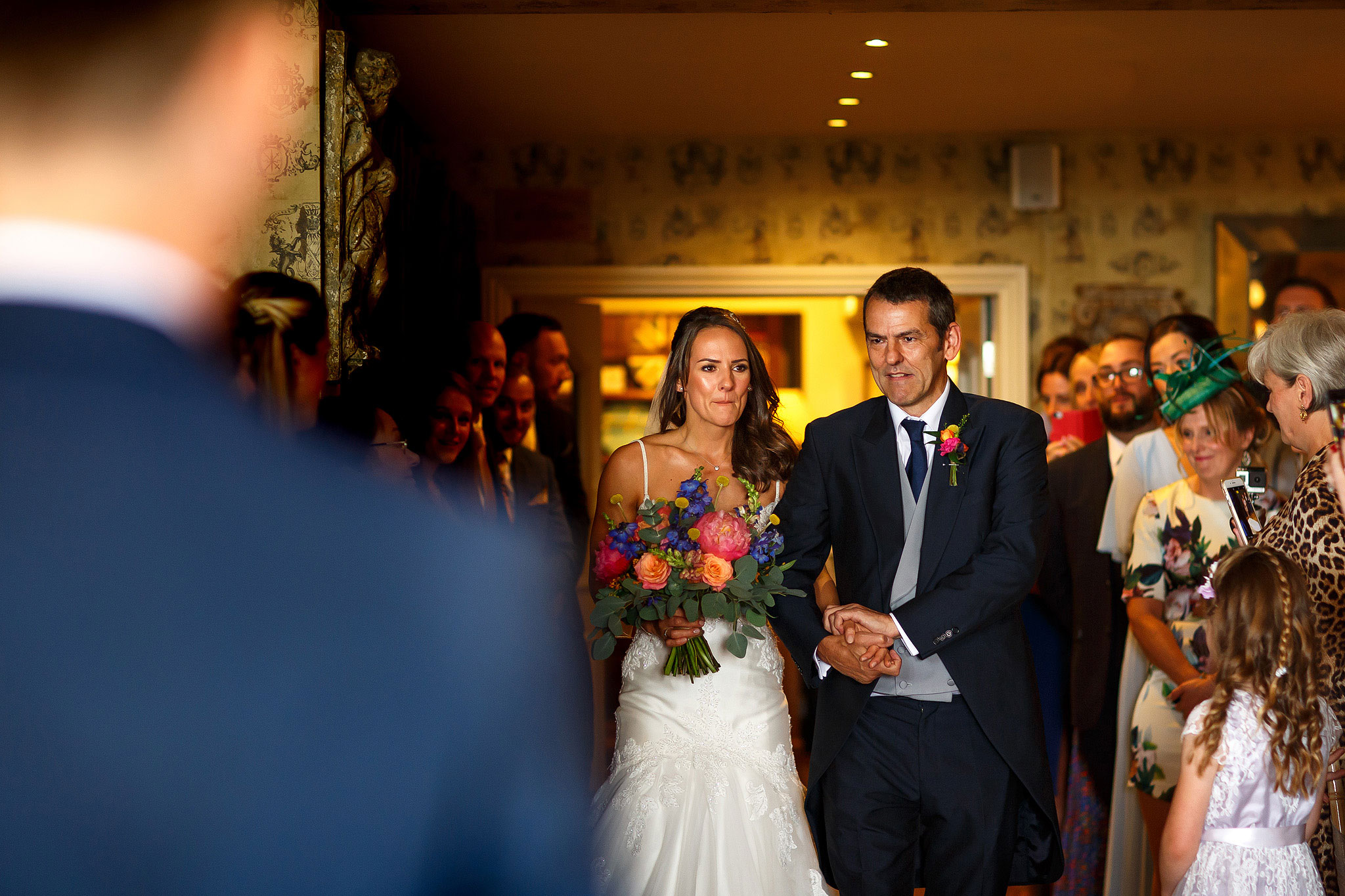 Bride walking down the aisle looking emotional with her father