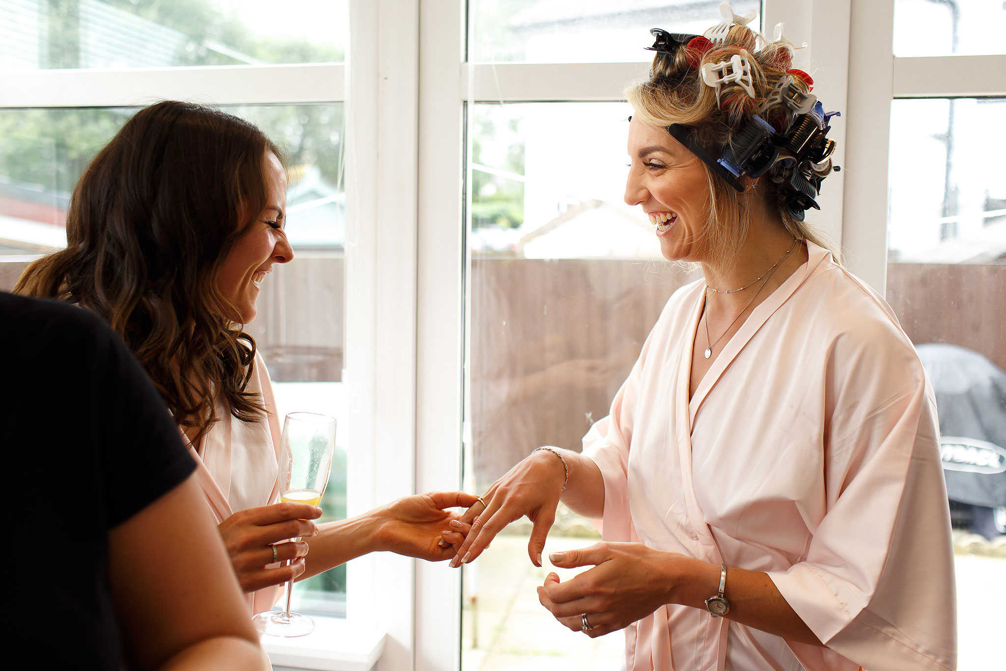 Bride showing off her engagement ring to bridesmaid