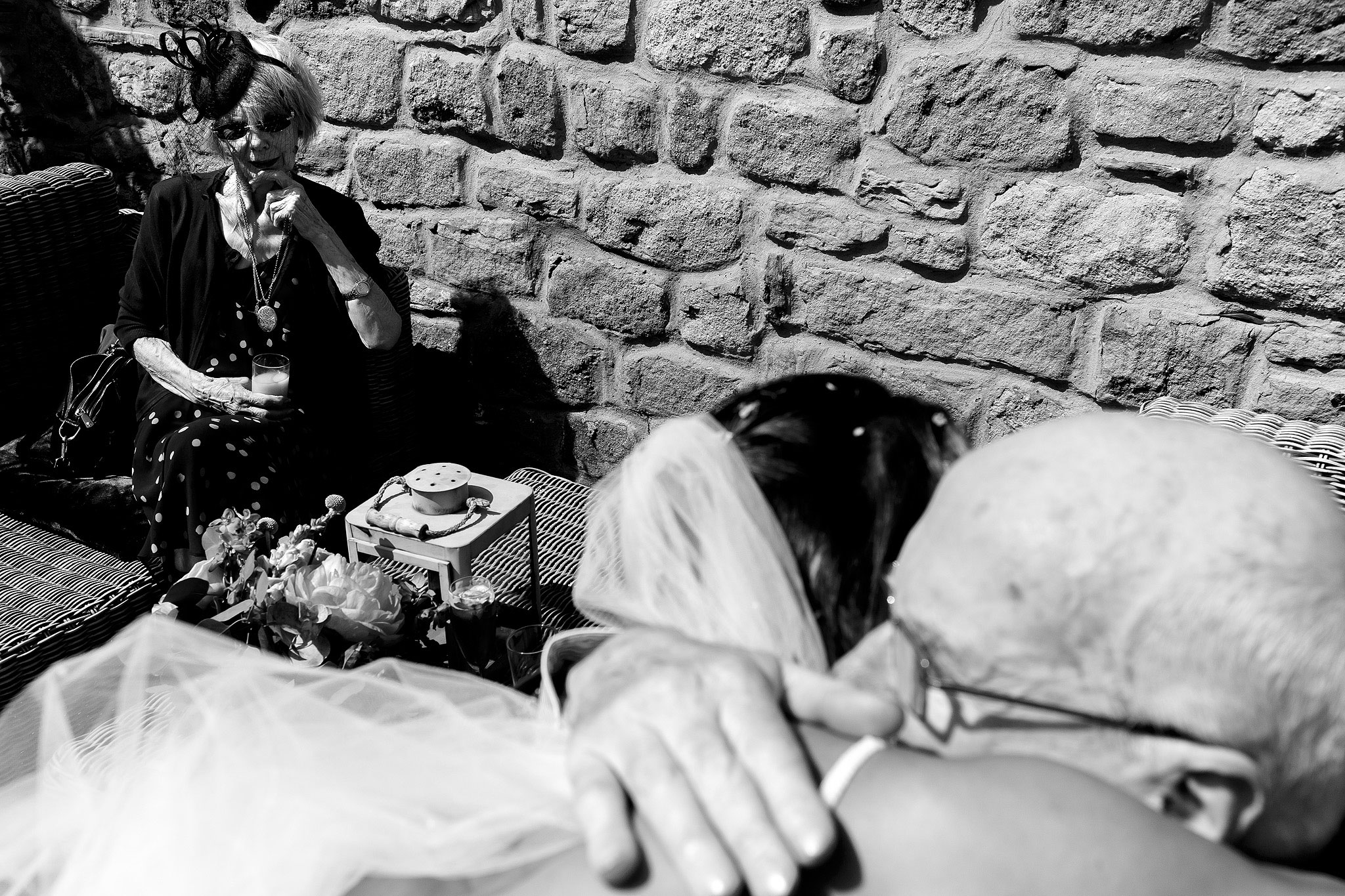 Bride hugging grandfather as grandma looks towards them and their embrace