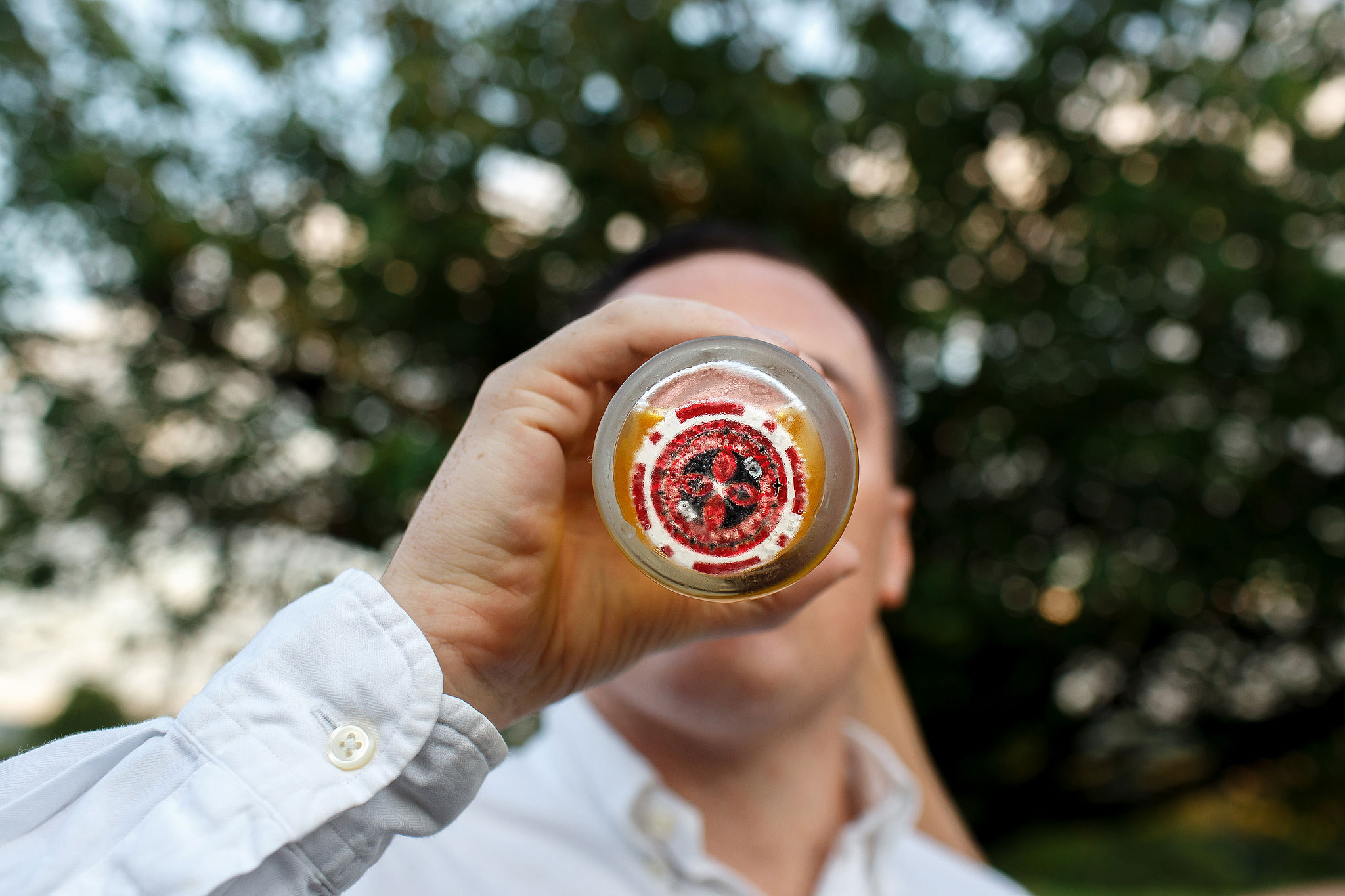 Wedding guests playing poker chip drinking game. Photograph of poker chip in bottom of pint glass. 