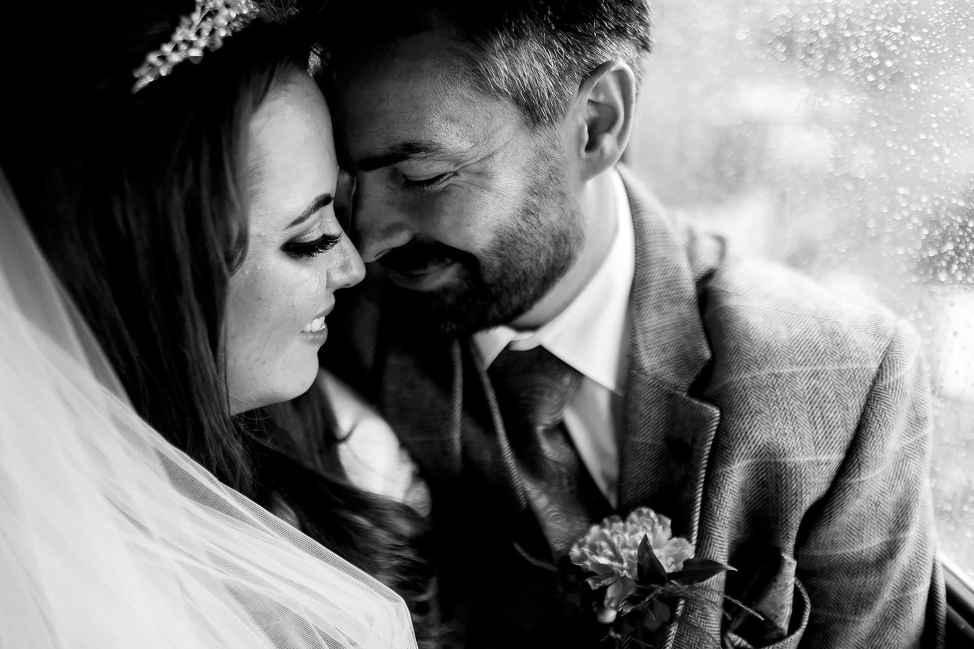 Bride and Groom enjoying a private moment on the wedding bus as rain falls on the window | Wellbeing Farm wedding photographs by Toni Darcy Photography