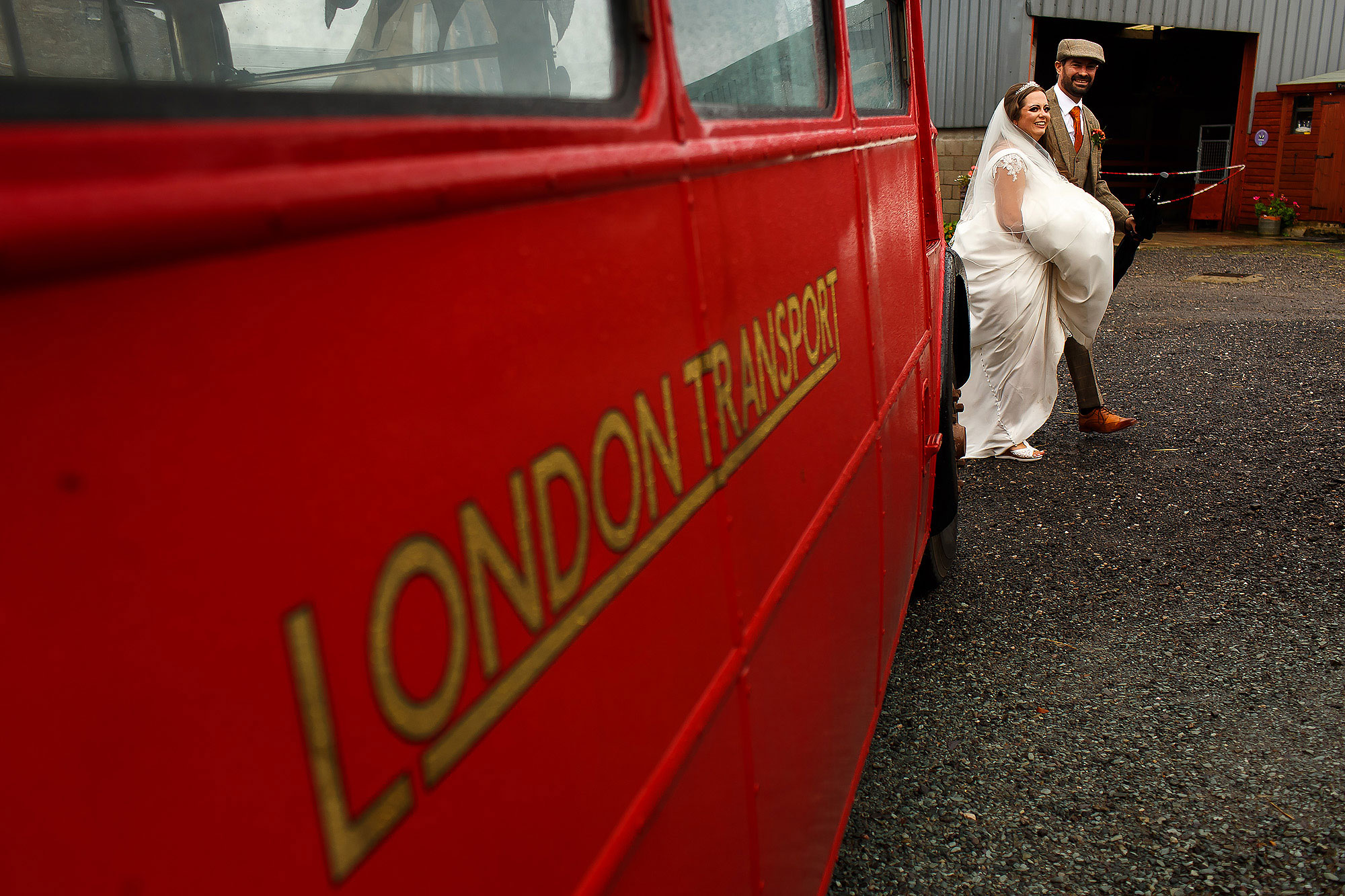 Bride and Groom walking to the wedding reception past the vintage London Transport Wedding bus | Wellbeing Farm wedding photographs by Toni Darcy Photography