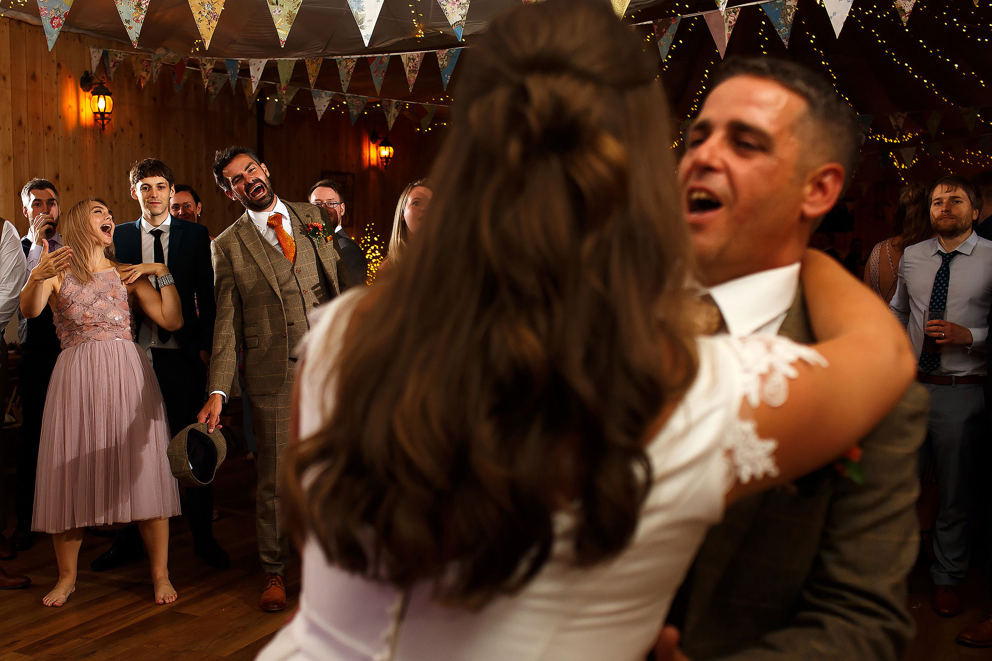 Bride dancing with her father as the wedding guests look onward singing | Wellbeing Farm wedding photographs by Toni Darcy Photography