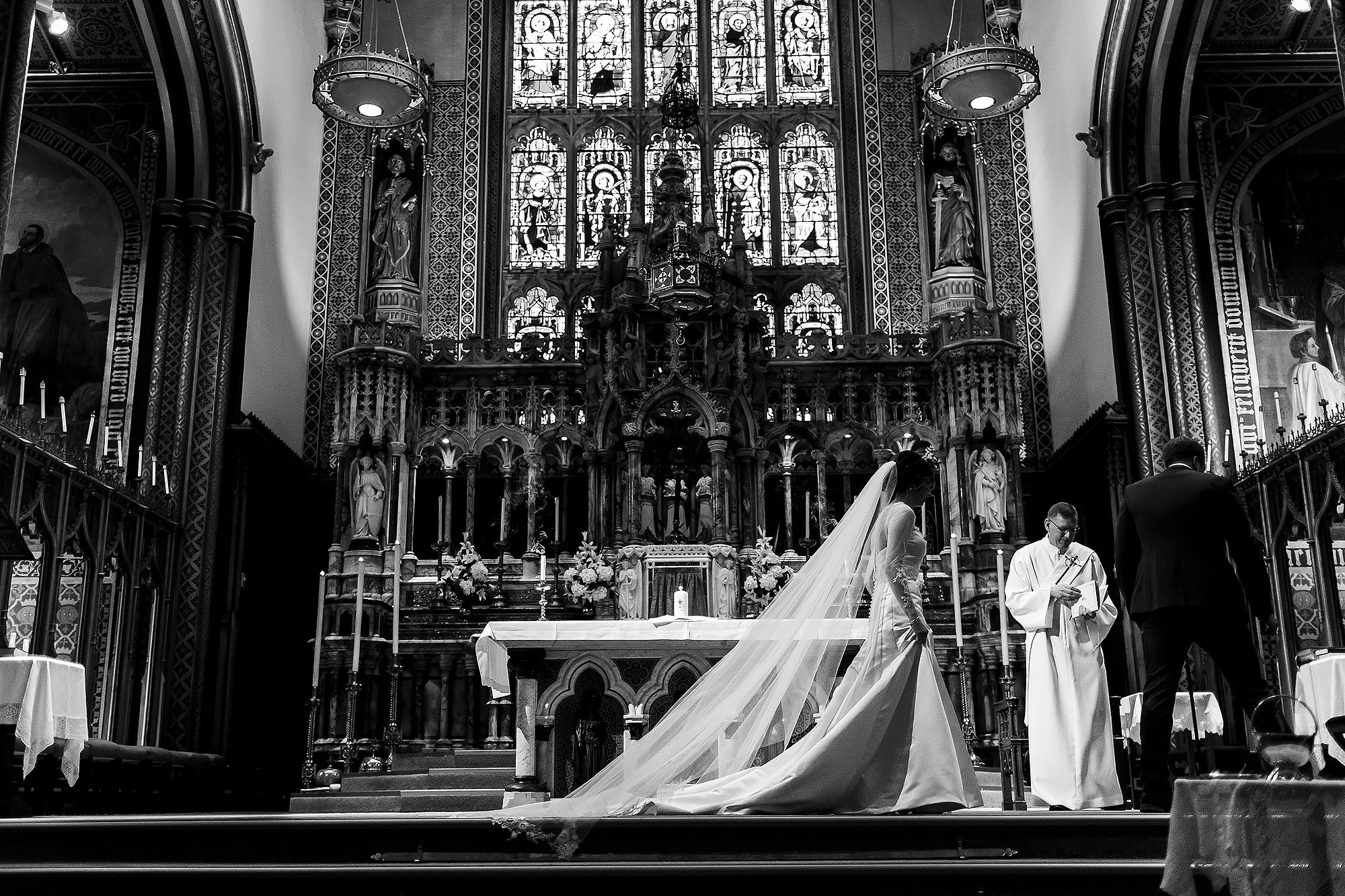 Bride walking across the altar as her long cathedral veil flows behind her | Mitton Hall wedding photographs by Toni Darcy Photography