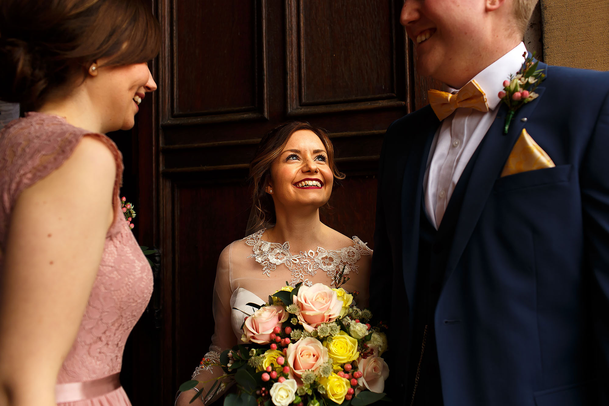 Bride and groom greeting wedding guests as they exit St Peters Stonyhurst after the wedding ceremony | Mitton Hall wedding photographs by Toni Darcy Photography