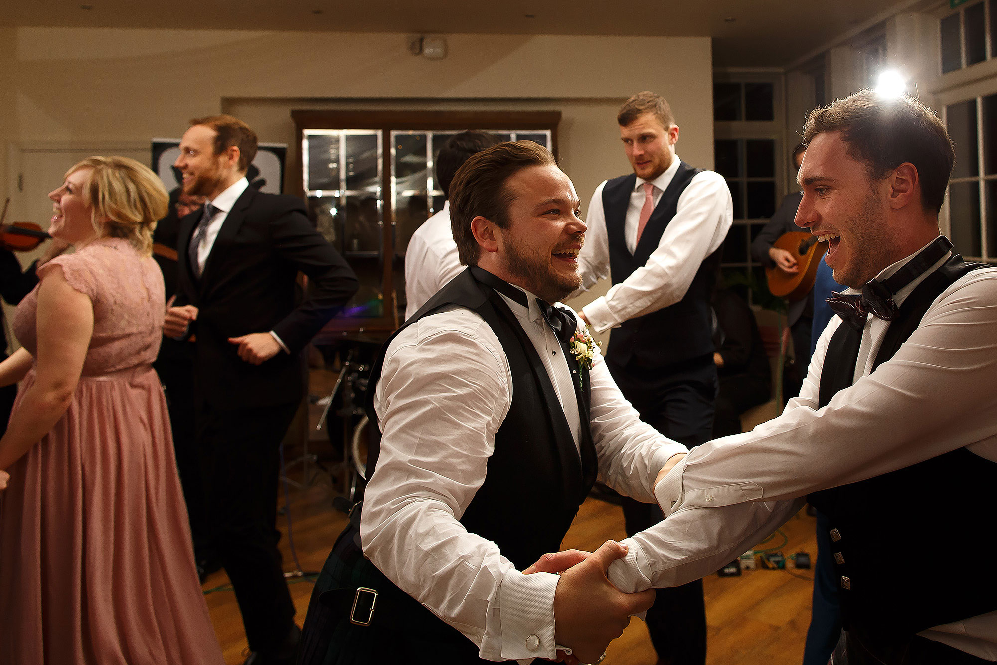 Wedding guests enjoying the ceilidh dancing | Mitton Hall wedding photographs by Toni Darcy Photography