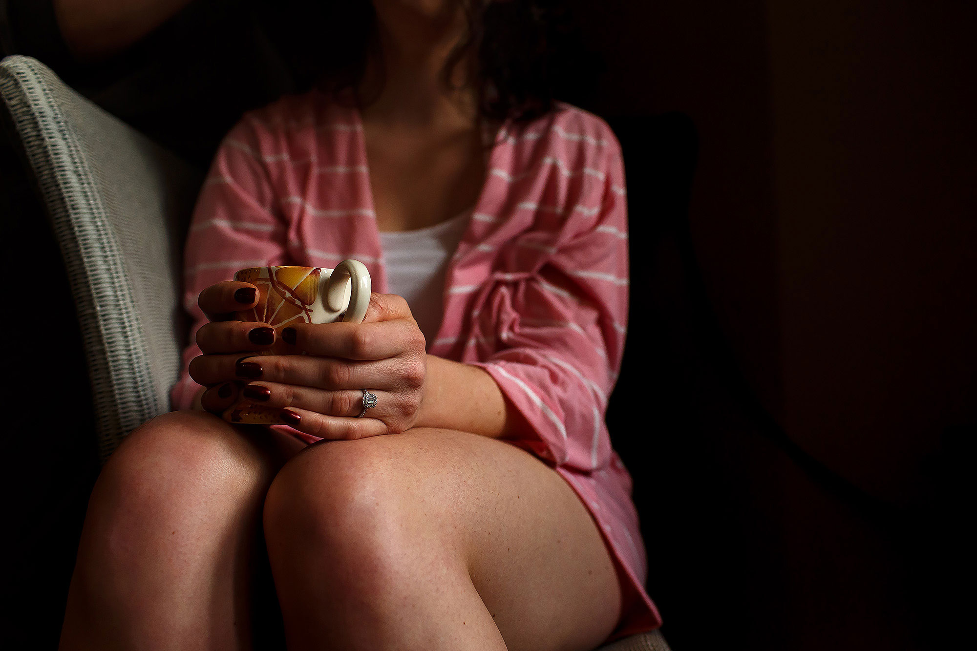 Bride holding cup of tea with both hands wrapped round showing her engagement ring off | Eaves Hall wedding photography by Toni Darcy