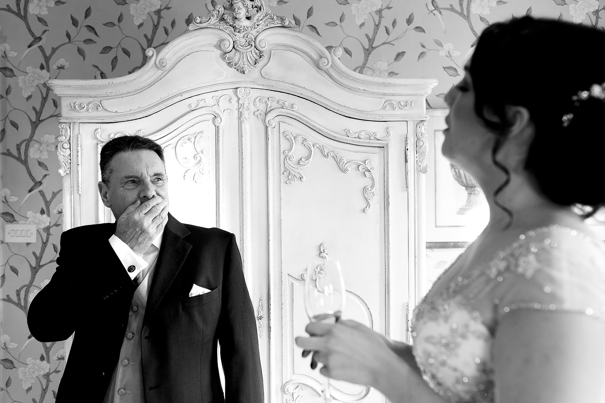Father of the brides holding his hand to his face as he sees his daughter in her wedding dress for the first time | Eaves Hall wedding photography by Toni Darcy
