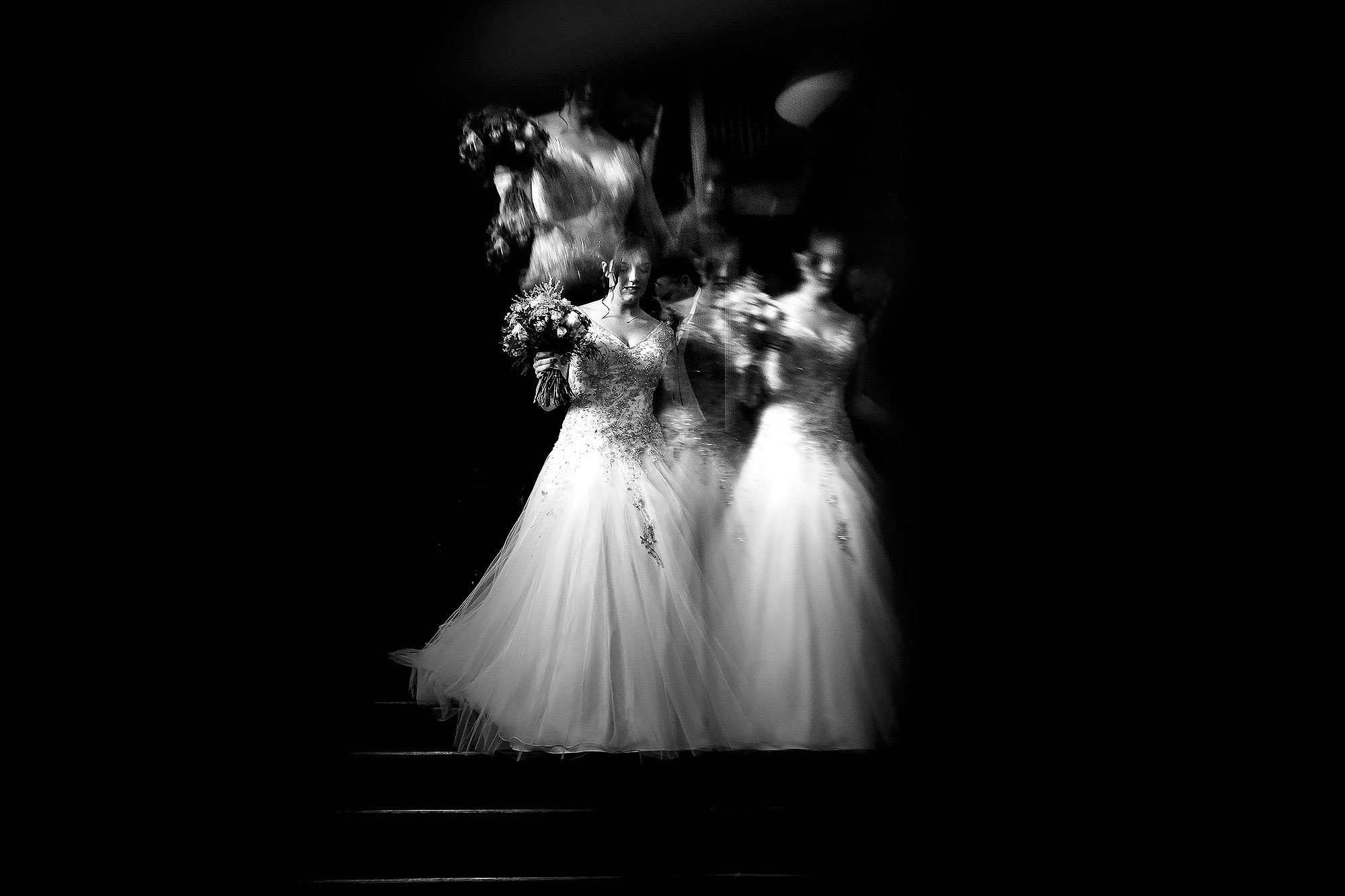 Bride walking down the staircase holding her wedding bouquet | Eaves Hall wedding photography by Toni Darcy