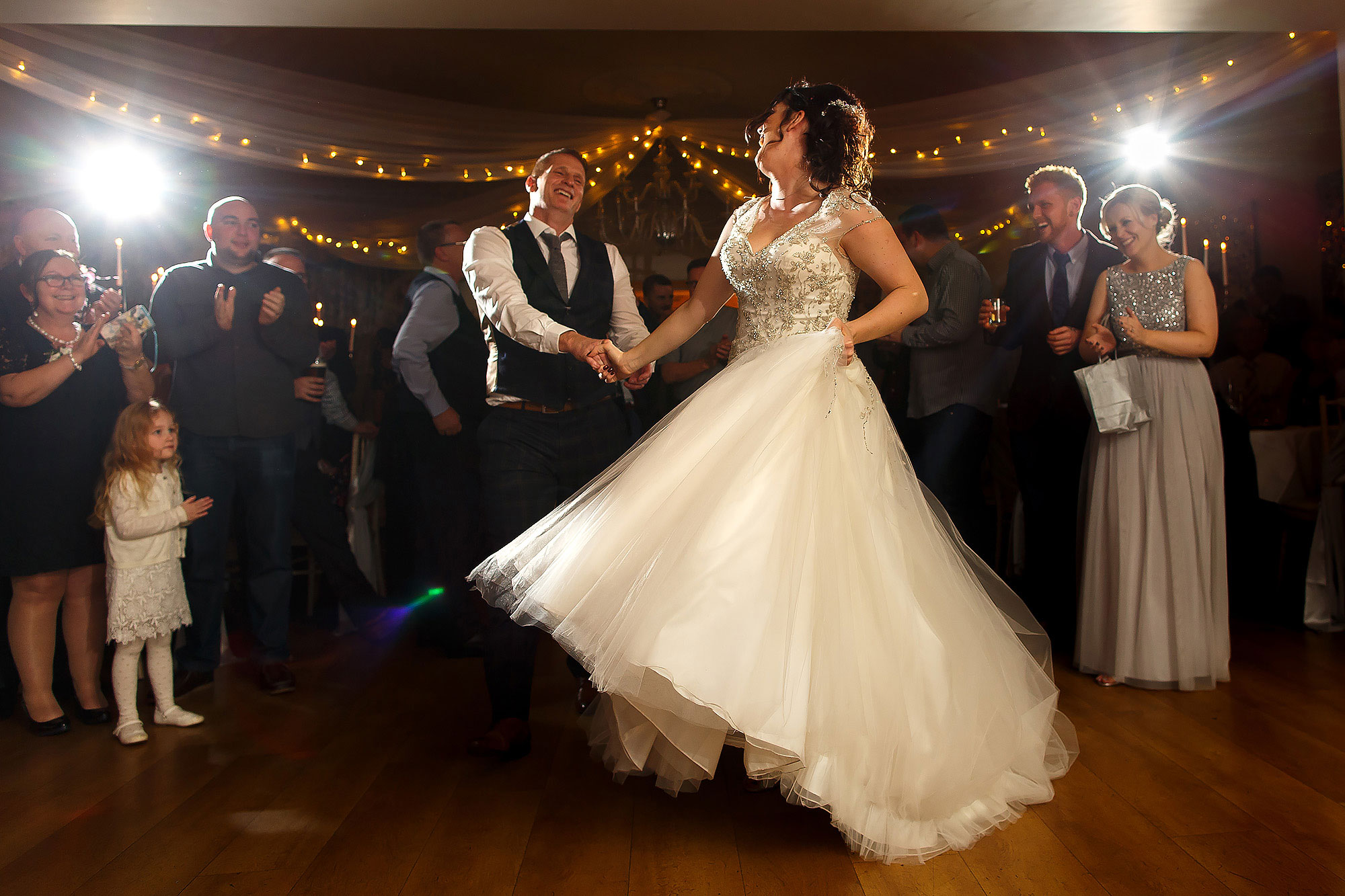 Bride and groom swinging each other round the dance floor with the wedding dress flowing | Eaves Hall wedding photography by Toni Darcy