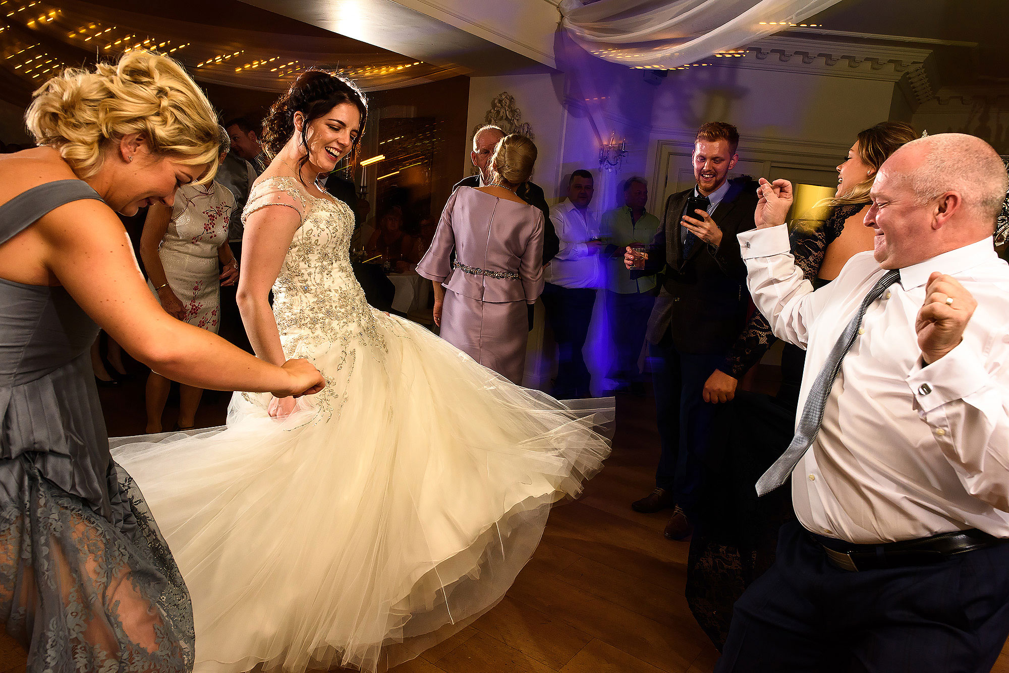 Bride throwing her dress round the dance floor with wedding guests | Eaves Hall wedding photography by Toni Darcy