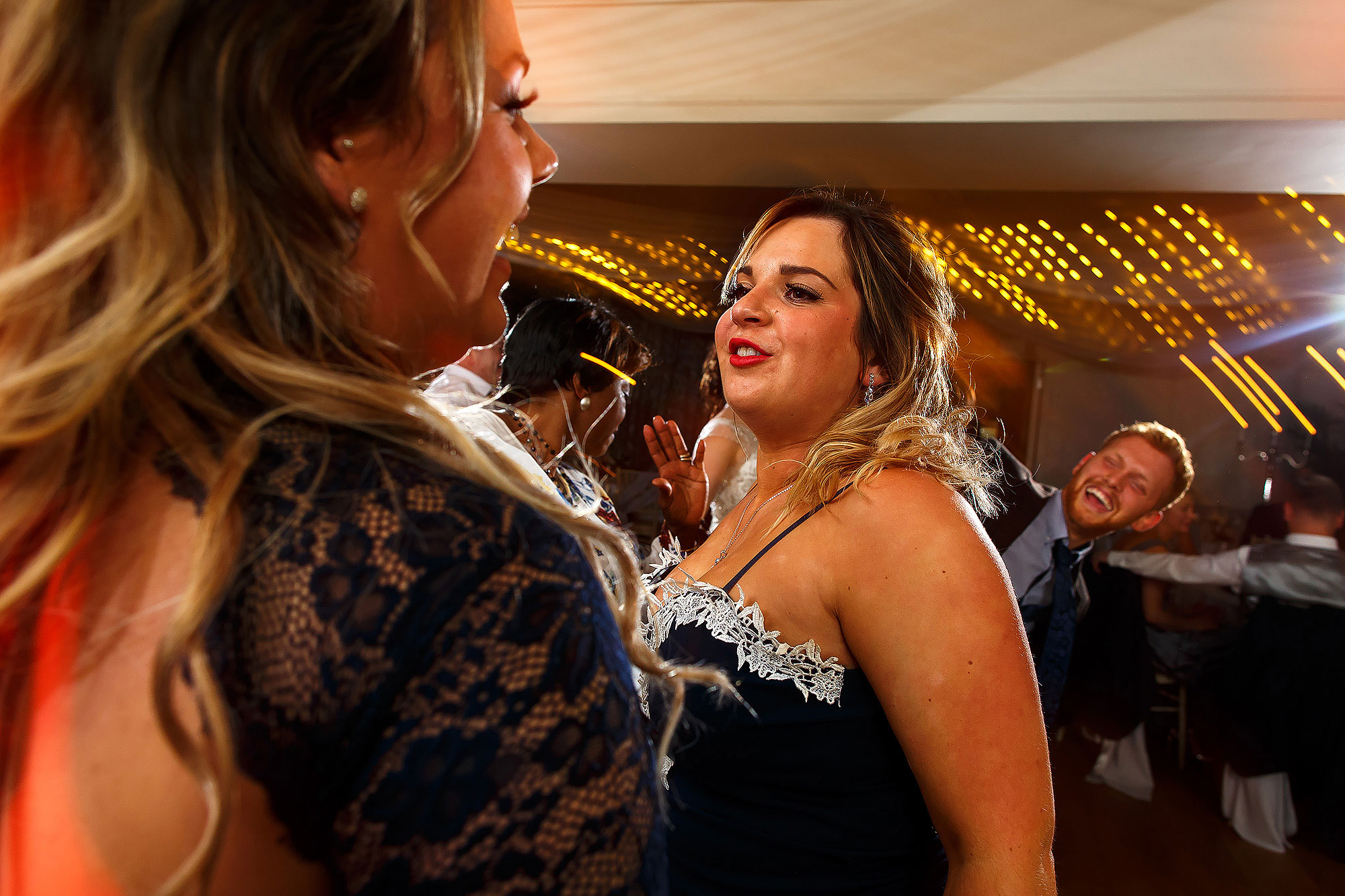 Wedding guests partying on the dance floor with light trails | Eaves Hall wedding photography by Toni Darcy