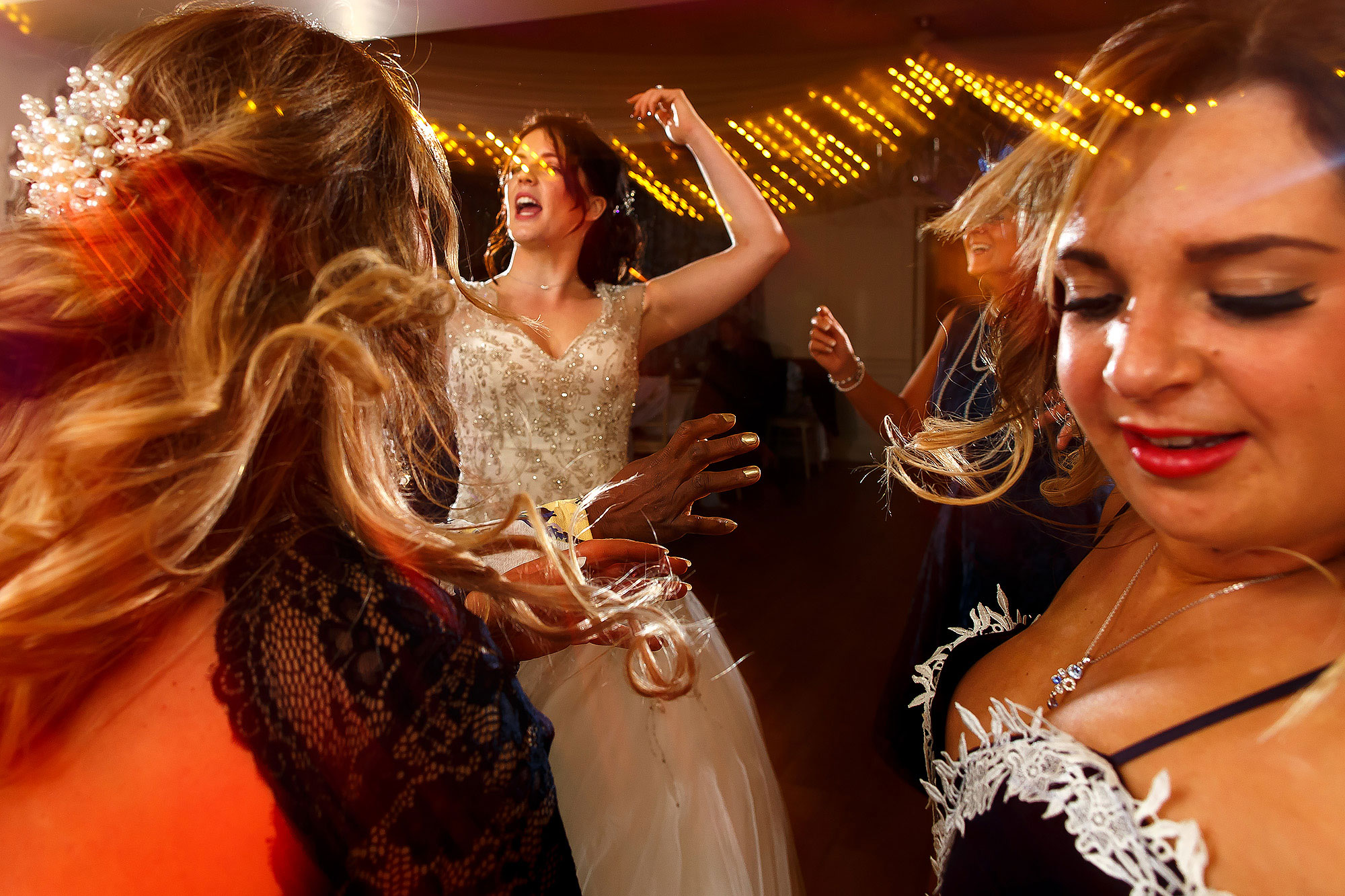 Wedding guests partying on the dance floor with light trails | Eaves Hall wedding photography by Toni Darcy